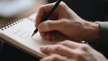 Someone writing on a journal