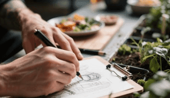 Social Media Hustle Guide Earn Online Successfully in 2025 Person drawing on a paper.